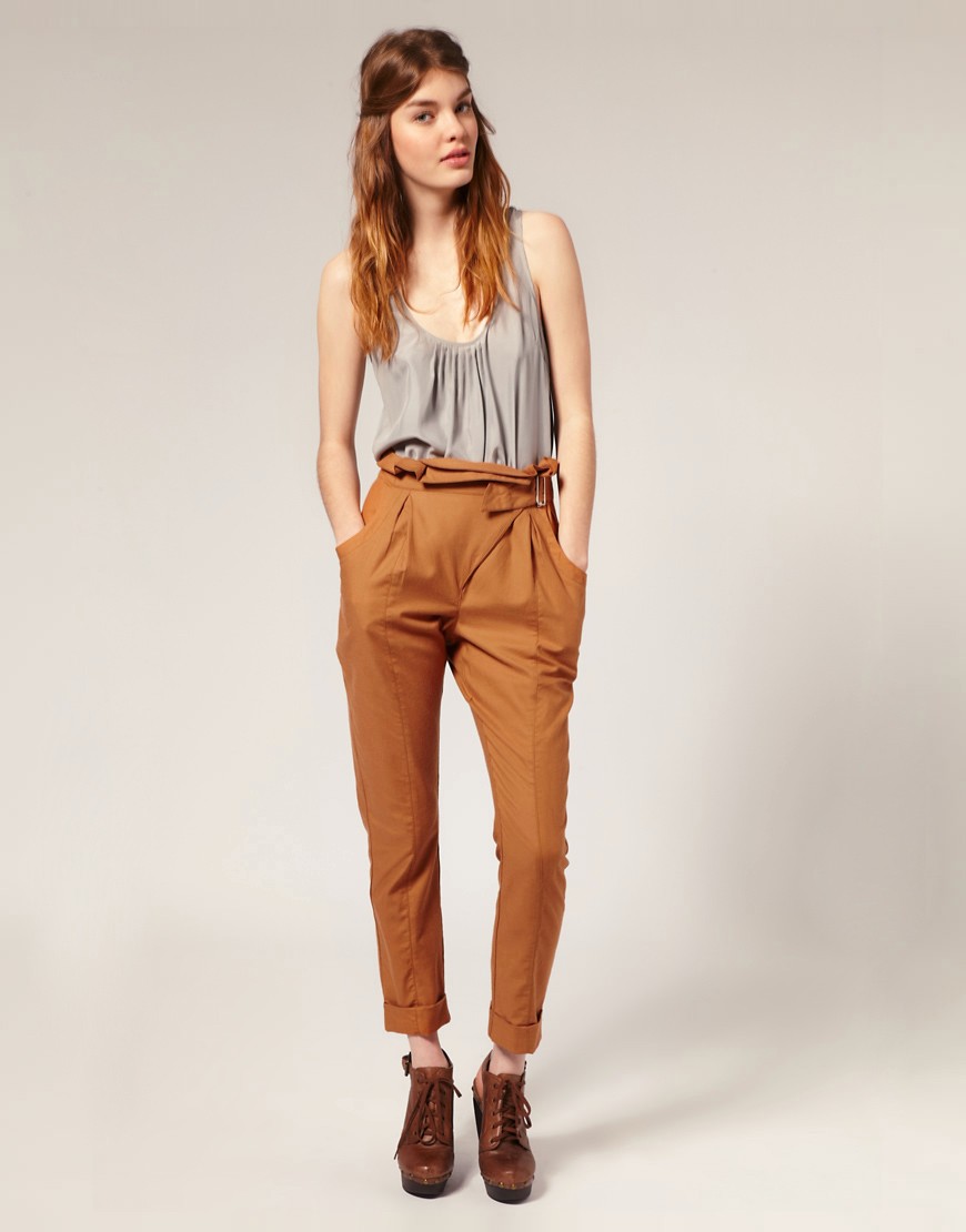 Model in grey top and brown high waisted pants